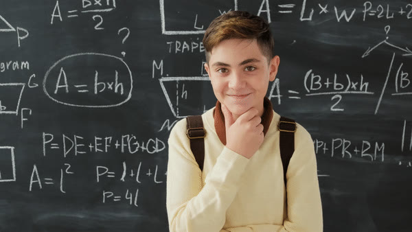 A pupil thinking in front of a chalkboard