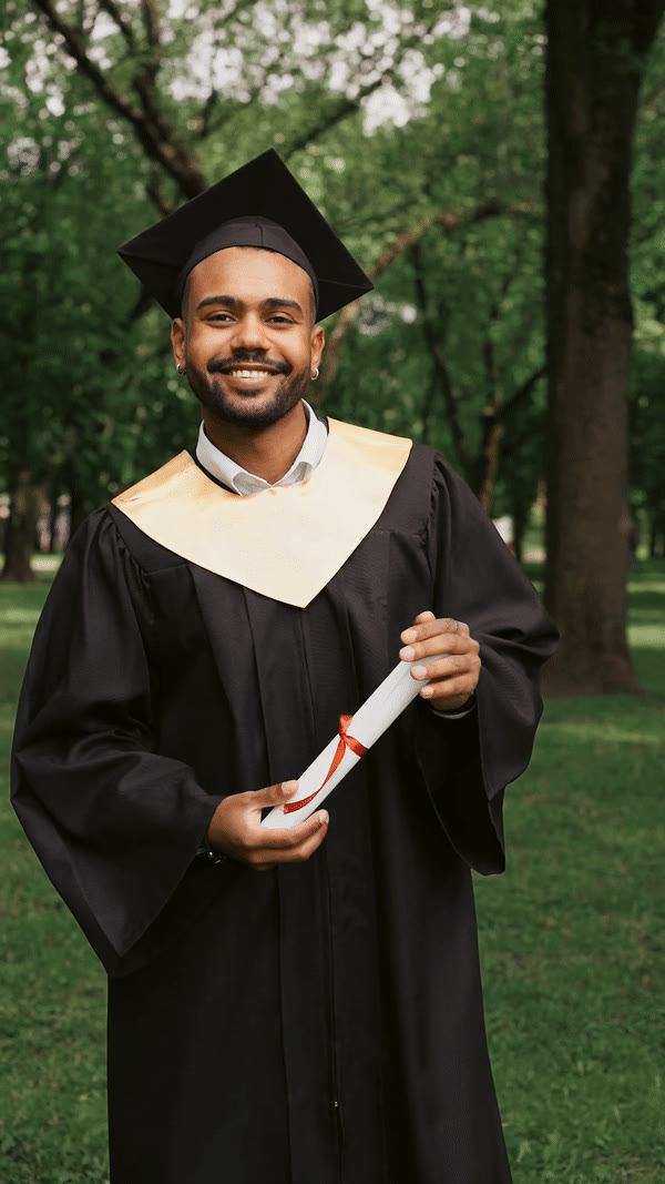 A graduate in cap and gown holding a certificate